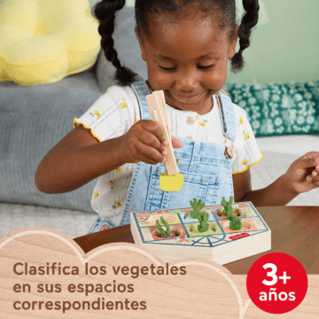 Niña jugando con el juego de clasificación de invernadero Fisher-Price desde los 3 años.