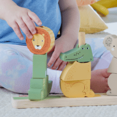 Manos de un niño combinando piezas de estos bloques de animales para apilar.