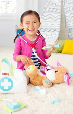 Niña examina a su peluche usando el set de doctor de 7 piezas Fisher-Price.
